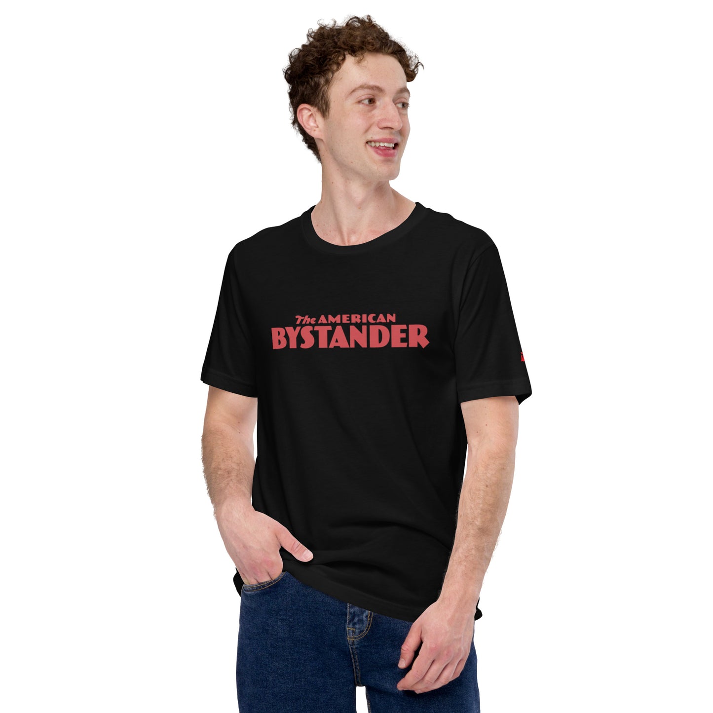 Tall, curly-haired man in his twenties sporting an American Bystander T-shirt, showcasing a casual yet distinctive look.